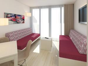 a hotel room with a purple bed and a table at Apartaments Ses Dàlies in Port d'Alcudia