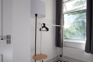 a shower in a bathroom with a wooden stool next to a window at Beeston House Manchester in Manchester