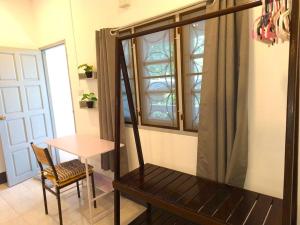 a room with a table and a chair and a window at Garden Home 6 in Ko Phangan