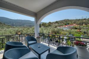 a balcony with chairs and a table and a view at Green Poetree Houses in Galatas