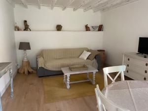 a living room with a couch and a table at Petite maison de charme à Thury in Thury
