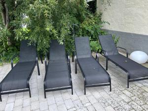 a group of black chairs sitting on a sidewalk at Villa i Fridhem centralt i Malmö in Malmö
