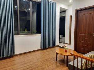 - un salon avec une table et quelques fenêtres dans l'établissement Sunshine villa, à Ấp Long Hồ Hạ 2 autres photos