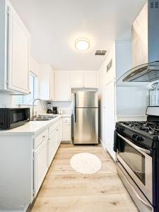 a kitchen with white cabinets and a stainless steel refrigerator at Charming 2-BR, 2-Story Home in Heart of LA - BR4 in Los Angeles +5 photos