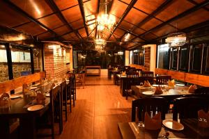 a dining room with tables and chairs in a restaurant at Yagappa Heritage Resort - Near Lake & Bus Stand in Kodaikānāl