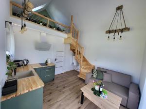 a kitchen and a living room with a staircase at Tiny house Sigulda in Sigulda