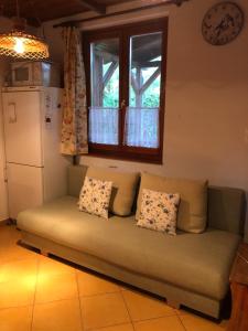 a couch in a living room with a window at Viola Apartman in Zamárdi