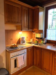a kitchen with wooden cabinets and a stove top oven at Viola Apartman in Zamárdi +13 photos