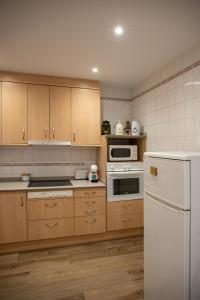 a kitchen with wooden cabinets and a white refrigerator at Apartament Perebep de Linyola in Linyola +15 photos
