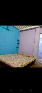 a mattress in a room with a blue wall at GOLDENGARDEN COTTAGES in Hampi +55 photos