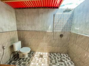 a bathroom with a toilet and a shower at Mimpi Bungalow in Gili Meno