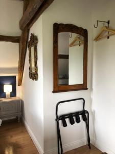 a mirror and a chair in a room at The Stable in Sourdeval