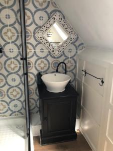 a bathroom with a sink and a mirror on a wall at The Stable in Sourdeval