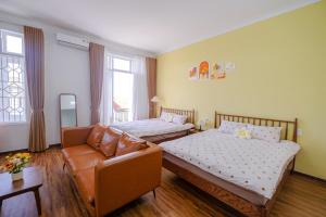 ein Wohnzimmer mit zwei Betten und einer Couch in der Unterkunft Mô Tê Homestay 2 gần Chợ Đông Ba, Cung Đình Hoàng Thành Huế in Hue