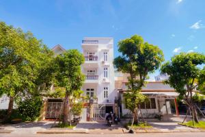 ein weißes Gebäude mit Bäumen davor in der Unterkunft Mô Tê Homestay 2 gần Chợ Đông Ba, Cung Đình Hoàng Thành Huế in Hue + 37 Fotos