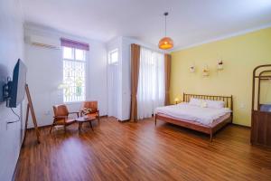 ein Schlafzimmer mit einem Bett und einem Tisch und Stühlen in der Unterkunft Mô Tê Homestay 2 gần Chợ Đông Ba, Cung Đình Hoàng Thành Huế in Hue