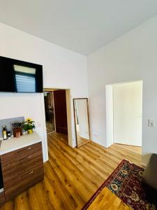 an empty living room with wooden floors and a flat screen tv at Komfortables Apartment mit dem gewissen Etwas in Braunschweig +12 photos