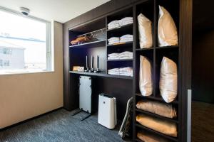 a room with a shelf with pillows and a window at Hotel GRAN THE PARK II in Hiroshima