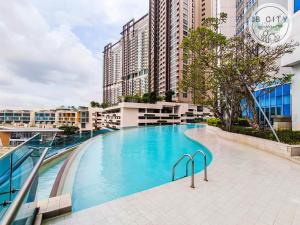 Kampong BaharuPine Tree Suites by RR JBcity的一座大型游泳池,位于部分建筑前