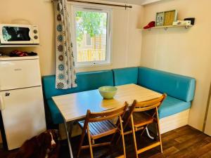 a kitchen with a table and a blue couch at Au cœur des Pins in Camiers +6 photos