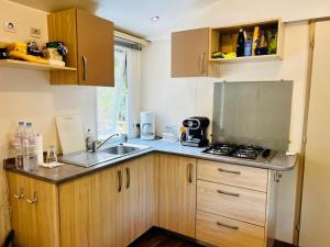a small kitchen with a sink and a stove at Au cœur des Pins in Camiers