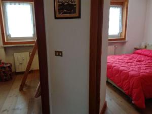 una camera con un letto rosso e due finestre di T333 Attico soleggiato con vista a Breuil-Cervinia
