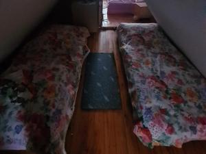 a bedroom with a bed with a floral bedspread on the floor at Idylissches Ferienhäusle im Thüringer Wald in Suhl