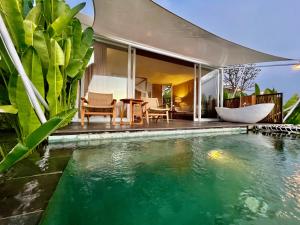 a house with a swimming pool next to a house at Harsa Eco Luxury Camp in Gobleg