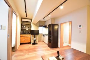 a kitchen with a refrigerator and wooden floors at NIYS apartments 01 type in Tokyo