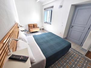 Un dormitorio con una cama y una silla y una puerta. en Rosa Dei Venti Guest House, en Cabras 24 fotos más