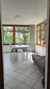 a living room with a table and chairs and windows at Ferienwohnung Familie Haas in Gößweinstein