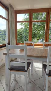 a dining room with a table and two chairs and windows at Ferienwohnung Familie Haas in Gößweinstein