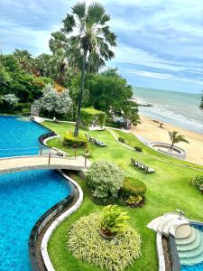 a swimming pool with a bridge and a beach at The Palm Wongamat 22 in North Pattaya