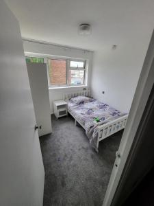un dormitorio con una cama y una ventana en Elm Park Home with Garden & Parking, en Hornchurch