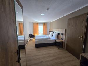 a bedroom with a bed and a desk and a window at Landgasthof Kreuz mit Gästehaus in Immendingen