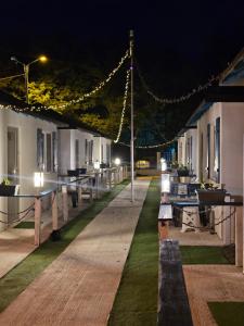 a row of tables and chairs at a resort at night at Holiday Village in Eforie Nord