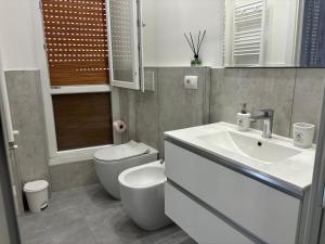 a bathroom with a white sink and a toilet at Appartamento Onda in Lido di Ostia