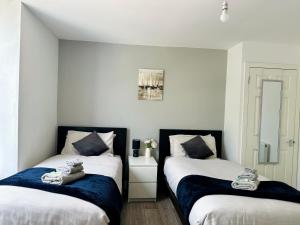 Giường trong phòng chung tại Cosy Modern 2 Bedroom Apartment - Neath Road Port Talbot Near Briton Ferry Train Station