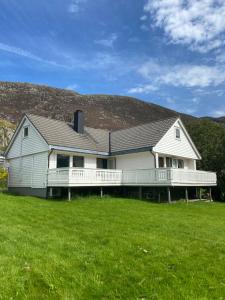 a large white house with a large yard at Honey bay cottage in Stadlandet