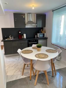 a kitchen with a table and chairs in a kitchen at Duplex neuf cosy centre Seclin in Seclin