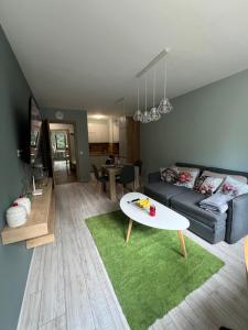 a living room with a couch and a table at Borovets Gardens Apartment B15 in Borovets