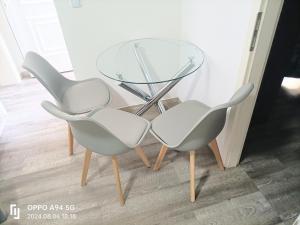 two white chairs sitting next to a glass table at FMI33 Next to Airport in Kelsterbach