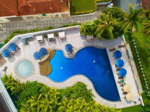 an overhead view of a resort swimming pool with palm trees at DoubleTree Resort by Hilton Hotel Penang in Batu Ferringhi