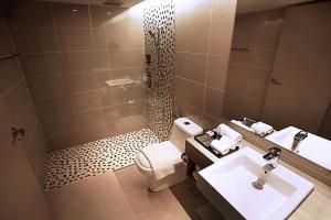 a bathroom with a toilet and a sink and a mirror at DoubleTree Resort by Hilton Hotel Penang in Batu Ferringhi