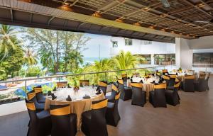 a restaurant with tables and chairs with a view of the ocean at DoubleTree Resort by Hilton Hotel Penang in Batu Ferringhi