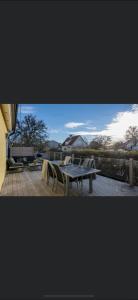 a patio with a table and chairs on a deck at Trevlig villa, centralt i Visby in Visby