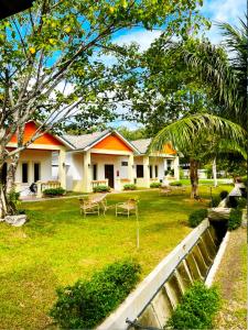 a house with a yard with chairs and trees at Dreamz Village in Tanjung Rhu