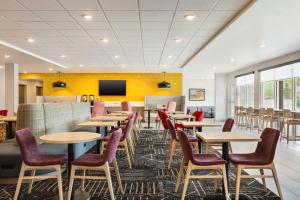 a dining room with tables and chairs and a tv at Home2 Suites Livingston Yellowstone in Livingston