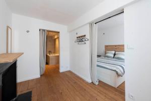 a white bedroom with a bed and a bathroom at Agréable maison de ville in Vincelles