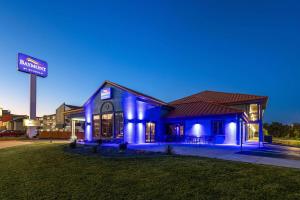 布兰森Baymont by Wyndham Branson Thousand Hills的晚上有加油站标志的蓝色房子